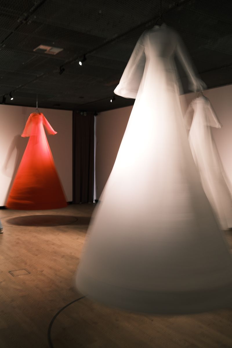 White and red dress sculptures in a gallery